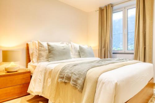 ein Schlafzimmer mit einem weißen Bett mit einem Fenster in der Unterkunft Casa do Pinheiro II, a Home in Madeira in São Vicente