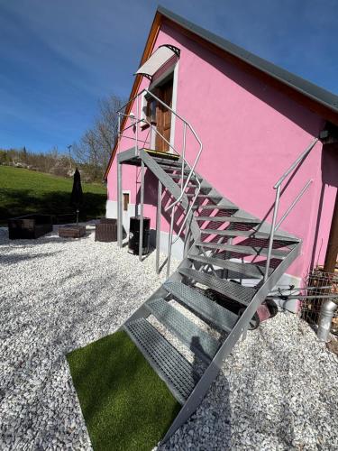 a staircase leading up to a pink building at Šumava apartmán U Kočiček in Strašice