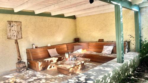 - une terrasse couverte avec des bancs et des tables en bois dans l'établissement VILLA située à 7 minutes du centre-ville de Porto-vecchio, à Porto-Vecchio