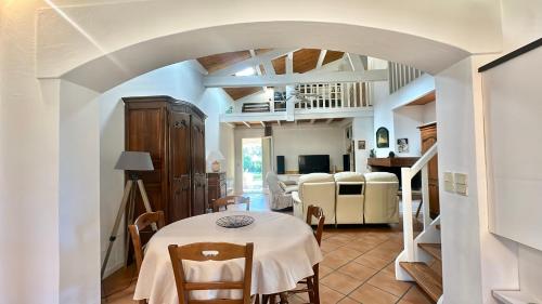 une salle à manger avec une table et des chaises blanches dans l'établissement VILLA située à 7 minutes du centre-ville de Porto-vecchio, à Porto-Vecchio