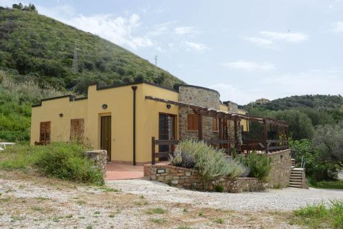 żółty budynek z wzgórzem w tle w obiekcie Appartamenti Le Giare Acciaroli w mieście Acciaroli