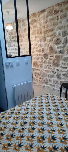une table dans une pièce avec un mur en pierre dans l'établissement appartement centre ville, à Avranches