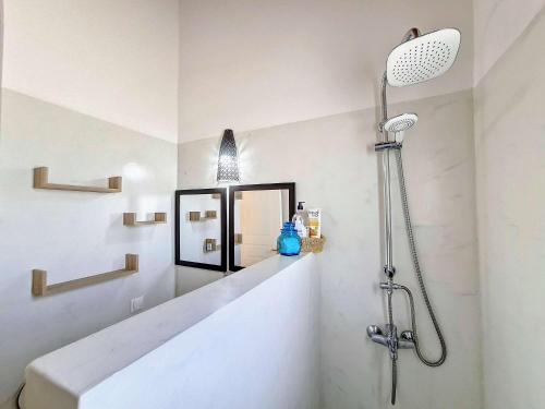 a white bathroom with a shower and a sink at Jolie villa proche des plages in Agios Aimillianos