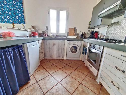 a kitchen with a washing machine and a dishwasher at Jolie villa proche des plages in Agios Aimillianos