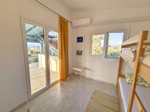 a bedroom with a bunk bed and a balcony at Hydra Bay Seaside Villa with Pool in Thermisia