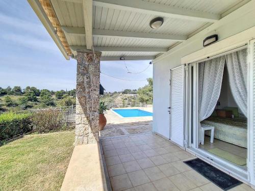 an open porch of a house with a pool at Seaview Villa with Pool for 6 in Porto Heli