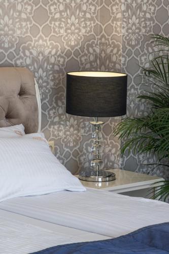 a lamp sitting on a table next to a bed at Moris Boutique Beach Hotel in Gdańsk