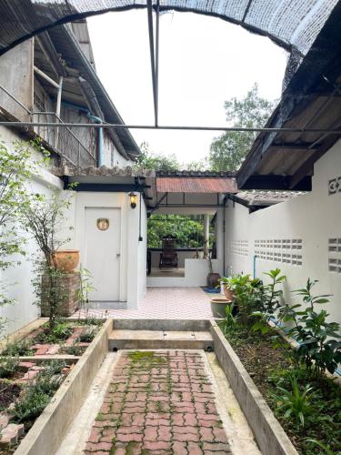 an internal courtyard of a house with a brick walkway at The Memory Hostel in Trat