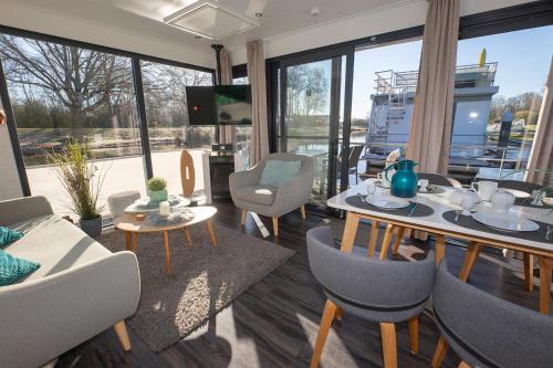 a living room with a table and chairs and a couch at Hausboot "Seestern" in Bad Bederkesa
