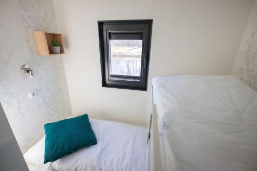 a small room with a bed and a window at Hausboot "Seestern" in Bad Bederkesa