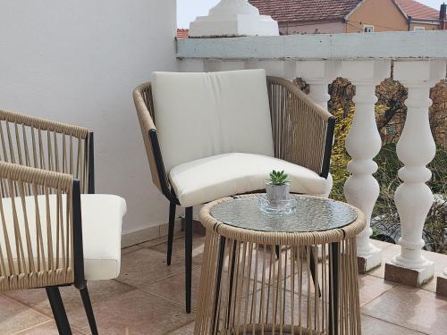 a white chair and a table on a balcony at Oleander Apartment 2 in Pakoštane in Pakoštane