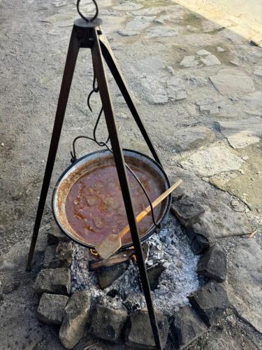 a bowl of soup in a pot over a fire at PGL in bucataria mamei- cazare la tara in Mălîncrav
