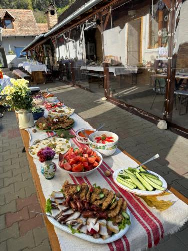 a long table with plates of food on it at PGL in bucataria mamei- cazare la tara in Mălîncrav