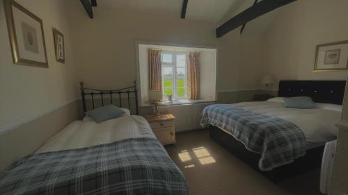 a bedroom with two beds and a window at The Sibson Inn Hotel in Water Newton