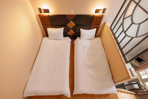 two beds in a room with a staircase at Hakuba Sun Valley Hotel in Hakuba