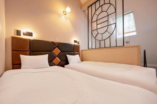a bedroom with two beds and a stained glass window at Hakuba Sun Valley Hotel in Hakuba