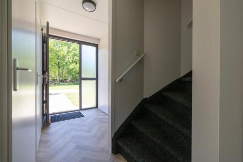 a hallway of a house with stairs and a door at Beautiful holiday home on park on swimming water in Ewijk