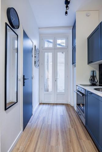 une cuisine avec des placards bleus et une porte bleue dans l'établissement 2#Cosy studio#Paris13#JardindesPlantes, à Paris