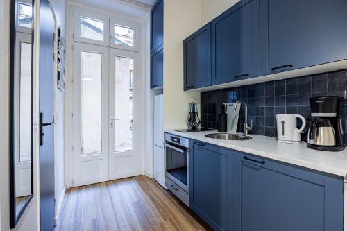 - une cuisine bleue avec évier et cuisinière dans l'établissement 2#Cosy studio#Paris13#JardindesPlantes, à Paris