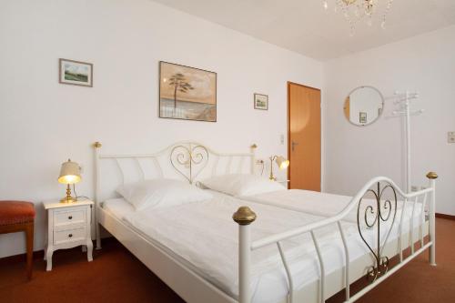 a bedroom with two white beds and a mirror at Hotel Garni Vitamari in Wasserburg am Bodensee