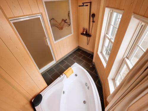 a small bathroom with a tub and a shower at Hakuba Sun Valley Hotel in Hakuba