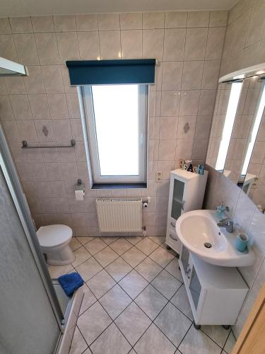 a bathroom with a sink and a toilet and a window at Ferienhaus Leonie in Barth