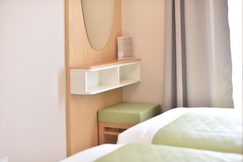 a room with two beds and a mirror and a bed at Résidence Saint-Jean in Saint-Florent