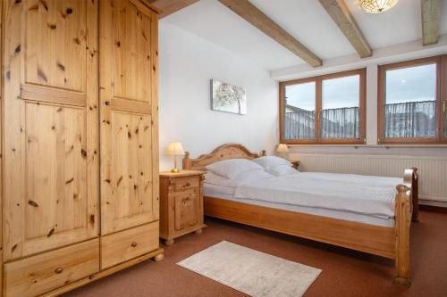 a bedroom with a bed and wooden walls and windows at Hotel Garni Vitamari in Wasserburg am Bodensee