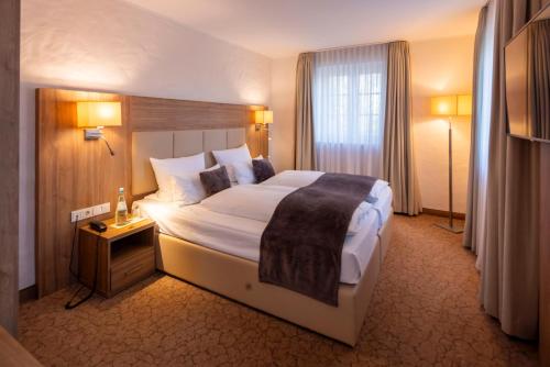 una camera d'albergo con un letto grande e una finestra di Parkhotel Hohenfeld Münster a Münster