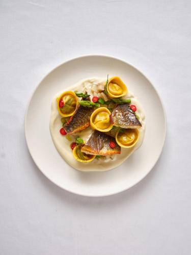 a plate of food with fish and rice on a table at Hotel Carmel  in Haifa