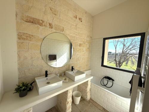 a bathroom with two sinks and a mirror at Domaine la Clausade in Mauguio