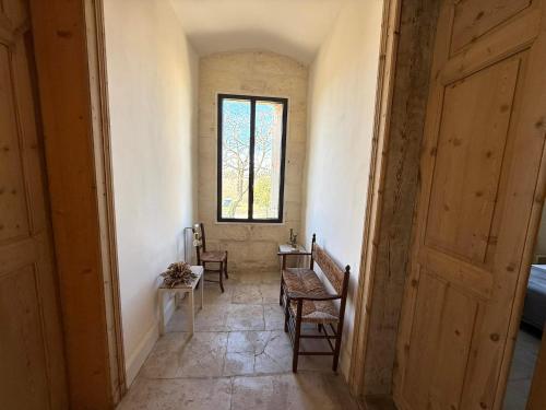a hallway with chairs and a window and a table at Domaine la Clausade in Mauguio