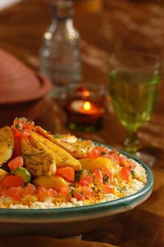 a plate of food with chicken and vegetables on a table at Le Bled Ferme in Marrakech