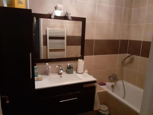 une salle de bain avec un lavabo, une baignoire et un miroir dans l'établissement Villa avec piscine proche mer, à La Celle-sous-Gouzon