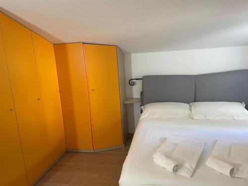 a bedroom with yellow cabinets and a bed with two towels at Confortevole camera matrimoniale con terrazza a 500 mt dal mare in Marina di Carrara