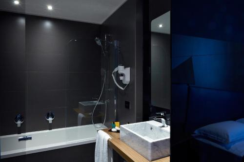 a bathroom with a shower, sink, and mirror at Hotel The Building in Rome