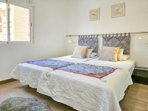 ein Schlafzimmer mit zwei Betten mit weißen Laken und einem Fenster in der Unterkunft One bedroom apartment central Fuengirola in Santa Fe de los Boliches