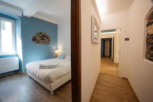 a bedroom with a bed with blue walls and a mirror at About Italy Holiday Rooms and Apartments in Portovenere