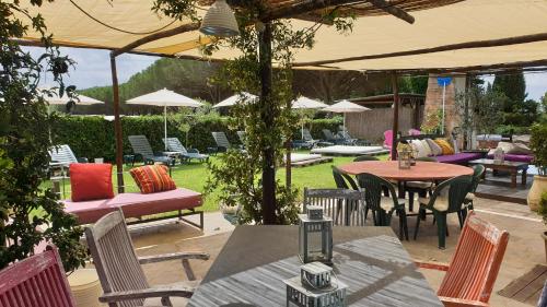 an outdoor patio with tables and chairs and umbrellas at Almanuda - Naturist Village - Adults Only in Sutri