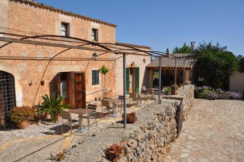 eine Terrasse mit Tischen und Stühlen vor einem Gebäude in der Unterkunft Can Porretí Agroturisme in Lloret de Vistalegre