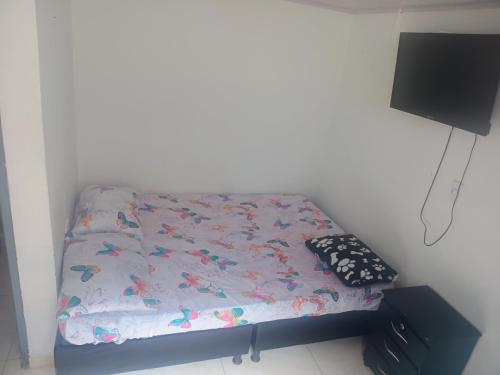 a small bed in a room with a tv at La fonda in Santa Rosa de Cabal