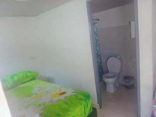 a small bedroom with a bed and a toilet at La fonda in Santa Rosa de Cabal