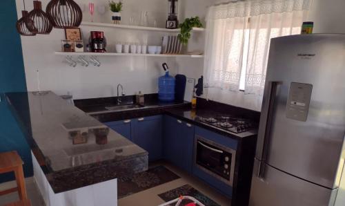 a kitchen with a refrigerator and a stove at Espaço Long Beach - Cabo Frio in Cabo Frio