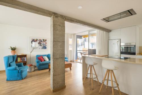 an open kitchen and living room with blue chairs at Fantastic beach apartment near Valencia in Valencia