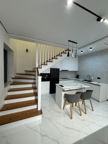 a kitchen with a staircase and a kitchen table and chairs at Atlantis resort, Issyk-kul in Chon-Sary-Oy