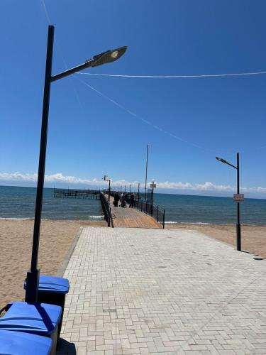 a beach with a street light and a pier at Atlantis resort, Issyk-kul in Chon-Sary-Oy