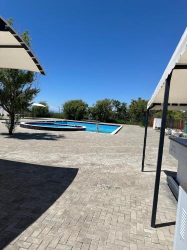 a patio with a swimming pool and an umbrella at Atlantis resort, Issyk-kul in Chon-Sary-Oy