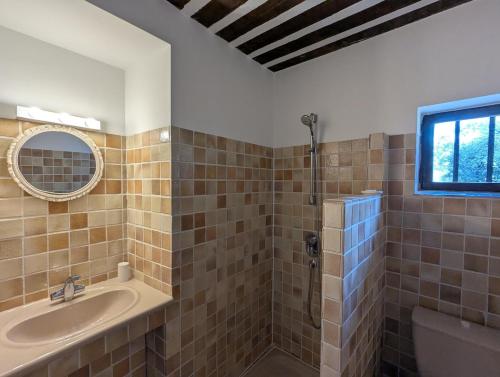 une salle de bain avec une baignoire, un lavabo et un miroir dans l'établissement Mas traditionnel à Gordes en pleine nature, à Gordes