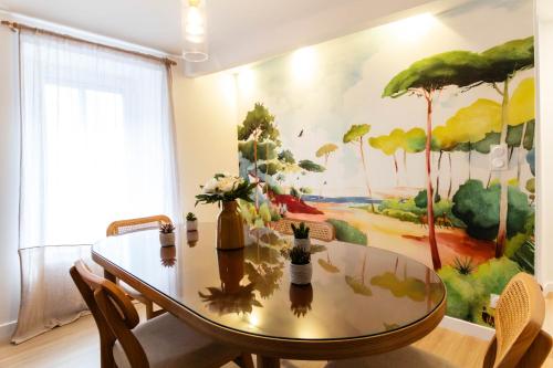 a dining room with a table and a painting on the wall at Romance & Evasion - Centre Ville - Love Room - Balnéo in Quimper