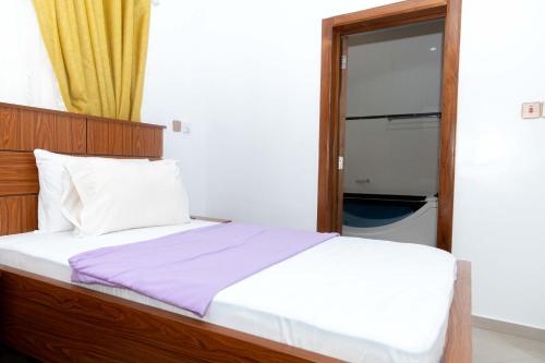 a bedroom with a bed and a door with a window at Ashanti Heritage Lodge in Kumasi